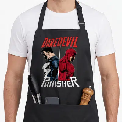 Tablier de cuisine noir avec Daredevil et le Punisher en illustration split screen rouge et bleu.