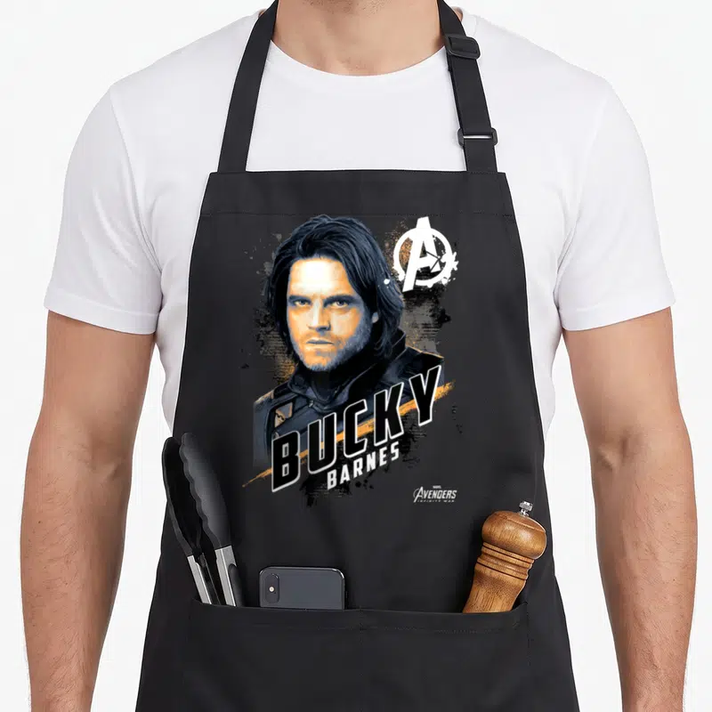 Tablier de cuisine noir avec portrait stylisé de Bucky Barnes et logo des Avengers en blanc et orange.
