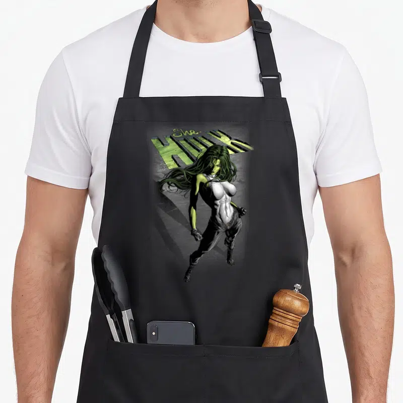 Tablier de cuisine noir avec illustration de She-Hulk et son logo vert stylisé.