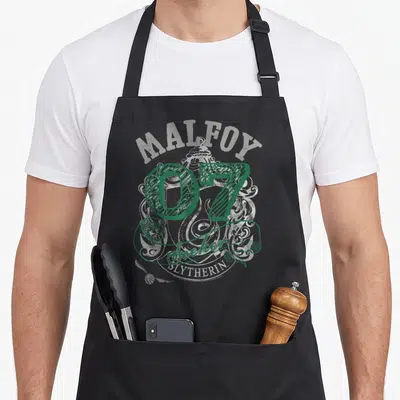 Tablier de cuisine noir avec l inscription Malfoy 07 Seeker Slytherin en vert et gris sur fond d armoiries stylisées
