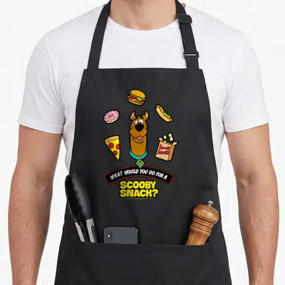 Tablier de cuisine noir avec Scooby-Doo au centre, des snacks colorés autour et le texte What Would You Do For A Scooby Snack en bas.