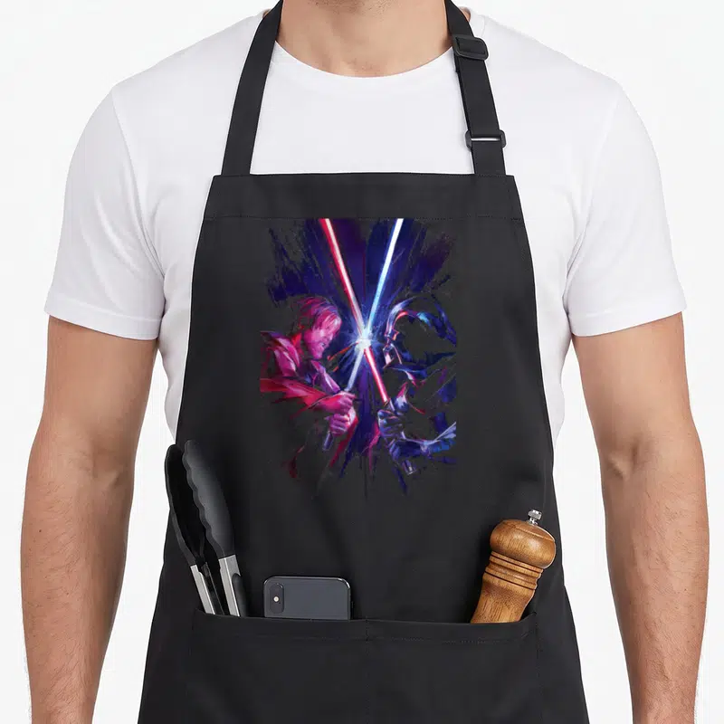 Tablier de cuisine noir avec illustration colorée d'Obi-Wan Kenobi et Darth Vader en duel au sabre laser.