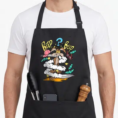 Tablier de cuisine noir avec Wile E. Coyote dans un nuage, le texte Beep Beep, une casquette rose et des lunettes rouges flottantes.