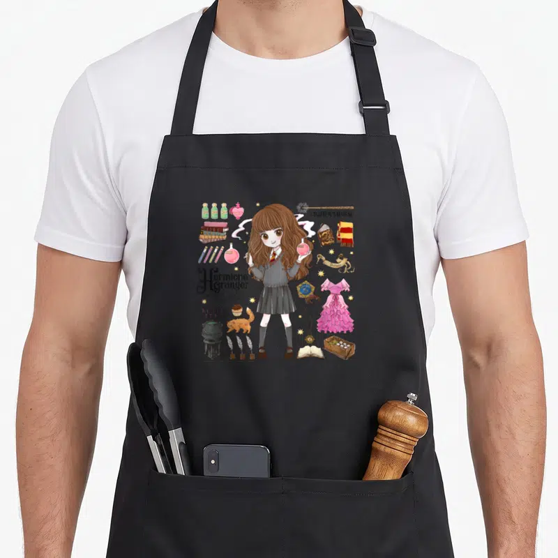 Tablier de cuisine noir avec illustration d'Hermione Grange entourée de fioles, livres et accessoires de magie.