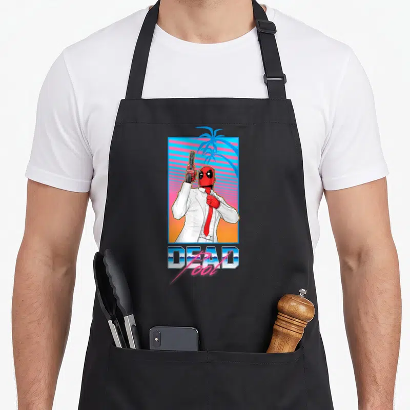 Tablier de cuisine noir avec Deadpool en costume blanc tenant un pistolet devant un fond tropical synthwave.