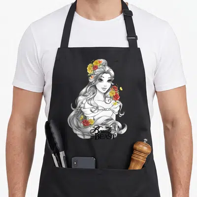 Tablier de cuisine noir avec portrait de Belle esquissé, roses colorées et titre Beauty and the Beast en bas.