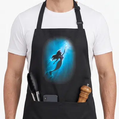Tablier de cuisine noir avec Ariel nageant vers la lumière sous l'eau en bleu électrique
