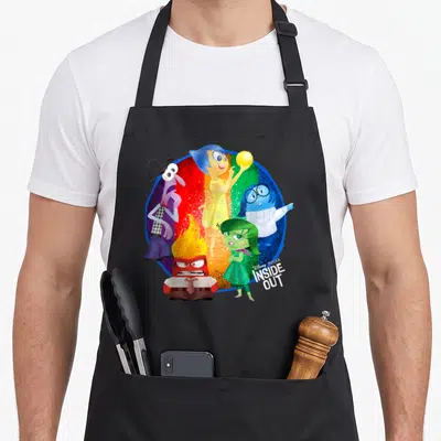 Tablier de cuisine noir avec les émotions de l'animation Pixar Inside Out disposées en cercle coloré.