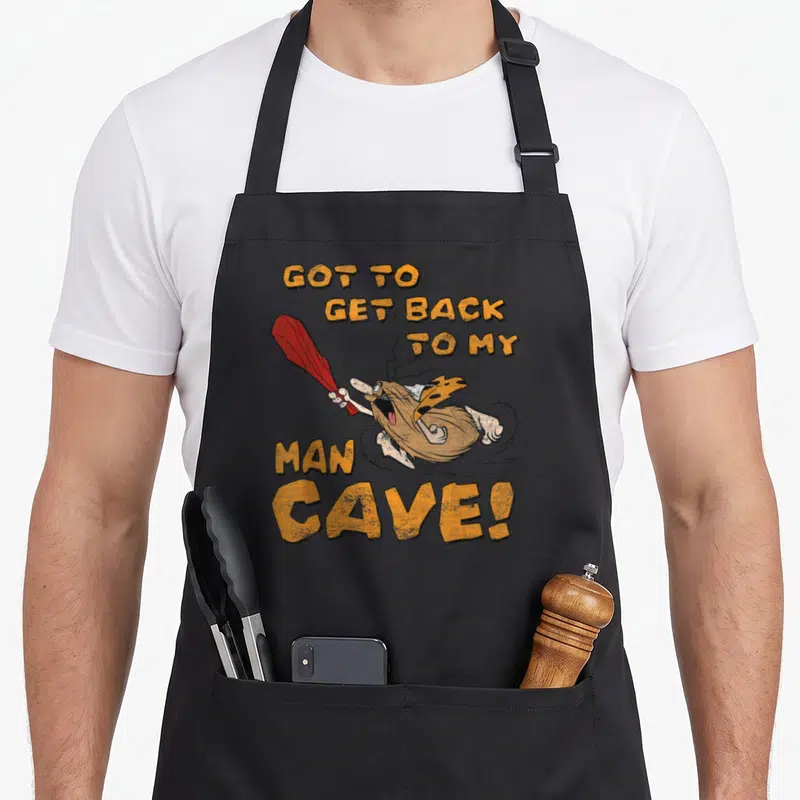 Tablier de cuisine noir avec Captain Caveman tenant une massue rouge et le texte Got to Get Back to My Man Cave.