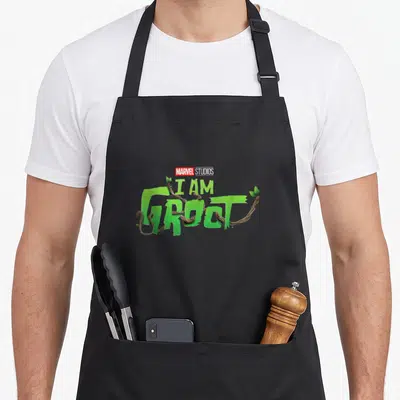 Tablier de cuisine noir avec le logo I Am Groot en lettres vertes et branches tordues.