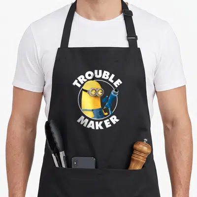Tablier de cuisine noir avec le Minion Tim tenant un pistolet à eau et l'inscription Troublemaker.