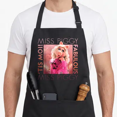 Tablier de cuisine noir avec Miss Piggy en tenue rose et le texte Tis Moi Fabulous.
