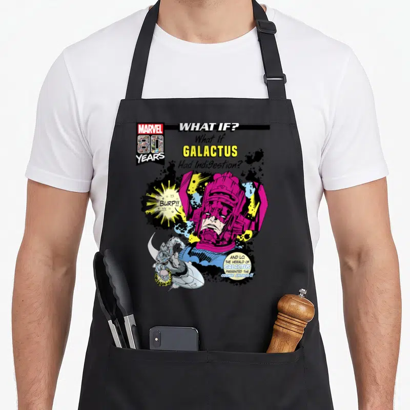 Tablier de cuisine noir avec illustration colorée de Galactus et texte What If Had Indigestion en style comic book vintage.