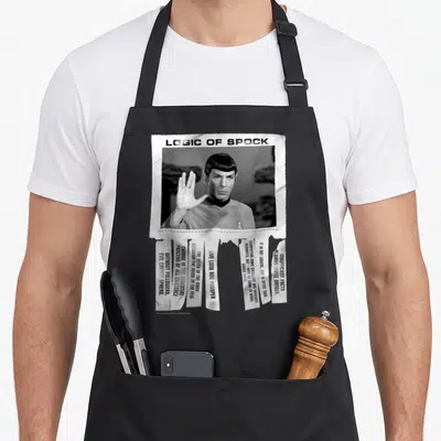 Tablier de cuisine noir avec une illustration en noir et blanc représentant Spock et des extraits de texte sur fond de papier déchiré.