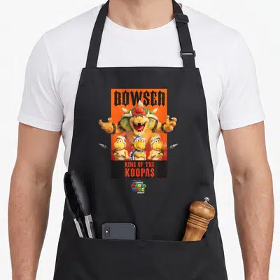 Tablier de cuisine noir avec l'affiche de Bowser King of the Koopas sur fond orange vif.
