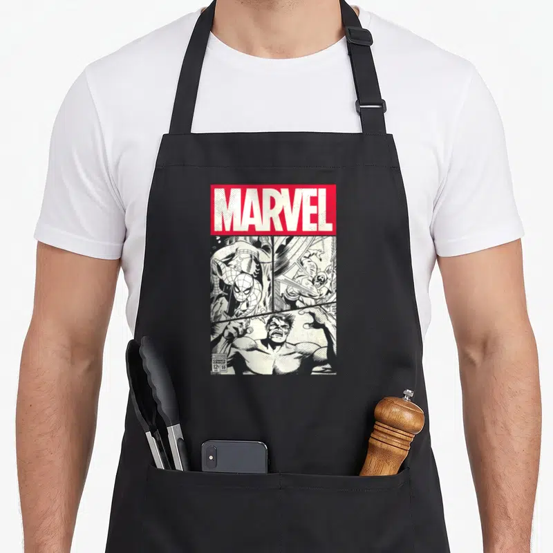 Tablier de cuisine noir avec une reproduction de couverture de comic book vintage en noir et blanc et un bandeau rouge supérieur.