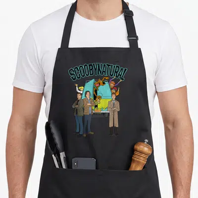 Tablier de cuisine noir avec illustration colorée du Mystery Ride et trois hommes en costume devant le véhicule.