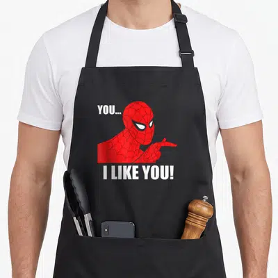 Tablier de cuisine noir avec Spider-Man pointant et le texte You I Like You en blanc.