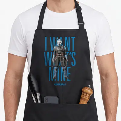 Tablier de cuisine noir avec Bo-Katan debout devant le texte I Want What's Mine en bleu.