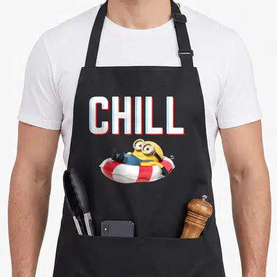 Tablier de cuisine noir avec un Minion allongé sur une bouée de piscine et le texte CHILL en grosses lettres.