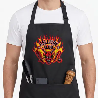 Tablier de cuisine noir avec un logo Hellfire Club représentant un démon aux flammes rouges et jaunes.