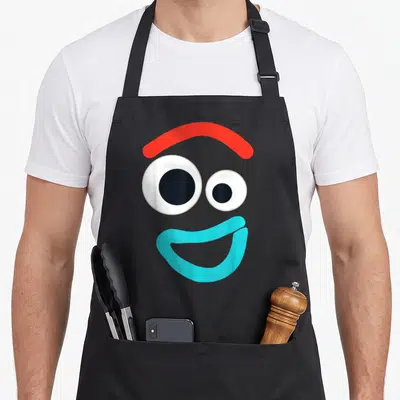 Tablier de cuisine noir avec le visage stylisé de Forky aux yeux ronds et bouche bleue.