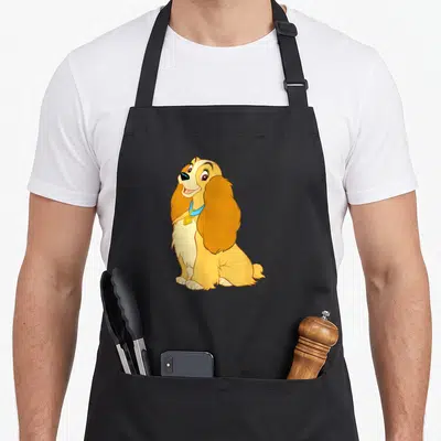 Tablier de cuisine noir avec une illustration colorée de Lady assise et souriante portant un collier bleu.