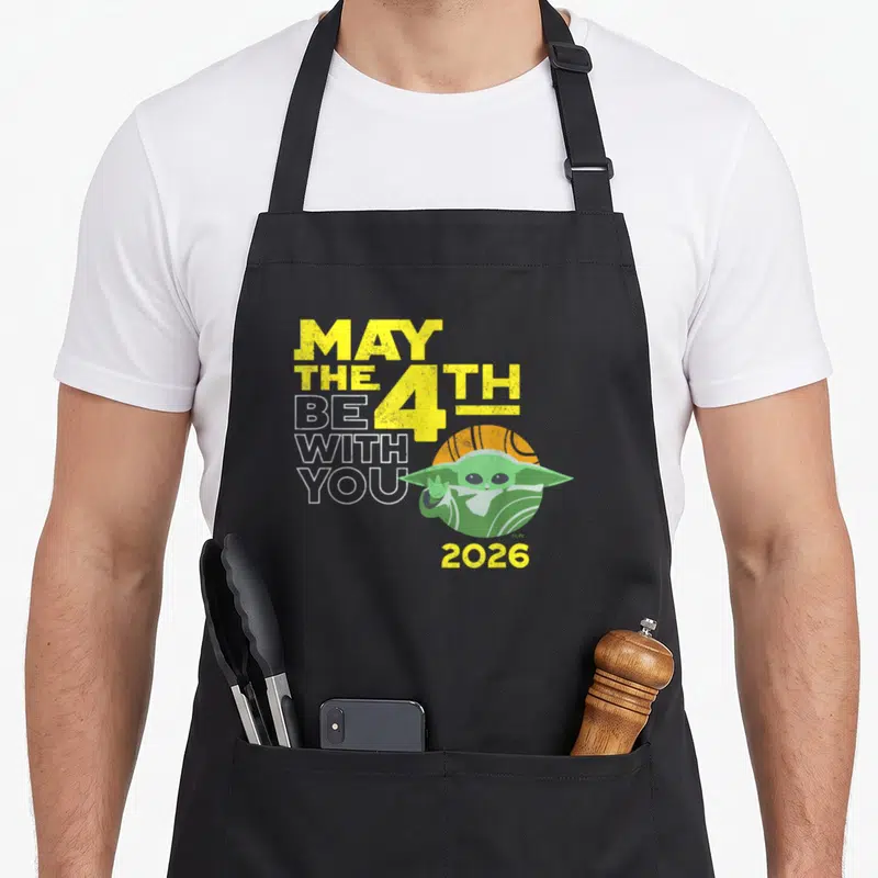 Tablier de cuisine noir avec May the 4th Be with You Grogu 2026 imprimé en jaune et vert.