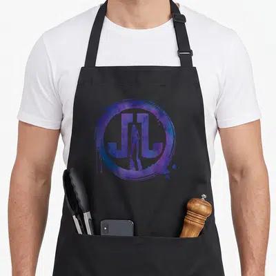 Tablier de cuisine noir avec logo JL violet et silhouette de Jessica Jones au centre.