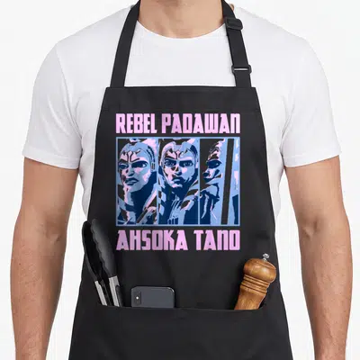 Tablier de cuisine noir avec illustration d'Ahsoka Tano et les textes Rebel Padawan et Ahsoka Tano en rose et bleu.