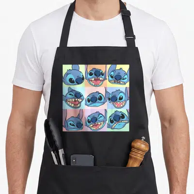 Tablier de cuisine noir avec neuf visages de Stitch aux expressions variées sur fond de carrés pastel colorés.