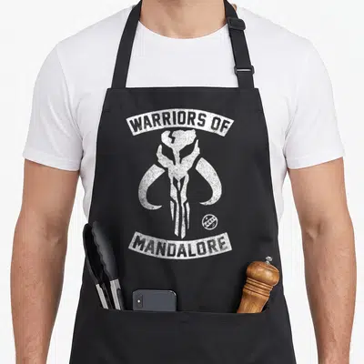 Tablier de cuisine noir avec le crâne de mythosaurien et l'inscription Warriors of Mandalore en blanc.