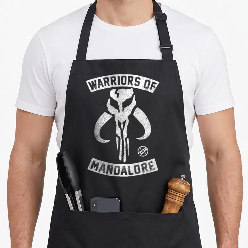 Tablier de cuisine noir avec le crâne de mythosaurien et l'inscription Warriors of Mandalore en blanc.