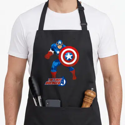 Tablier de cuisine noir avec Captain America The First Avenger en pose dynamique tenant son bouclier circulaire.