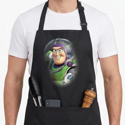 Tablier de cuisine noir avec illustration colorée de Buzz l'Éclair souriant en combinaison verte et casque transparent.