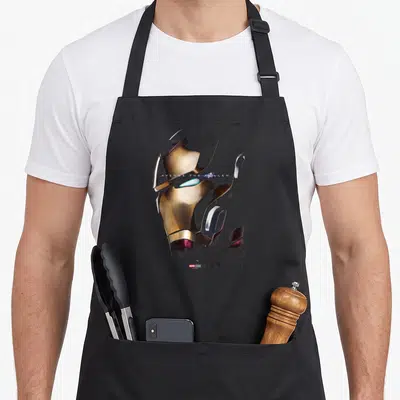 Tablier de cuisine noir avec le visage métallique d'Iron Man et le texte Avenge The Fallen imprimé en blanc.