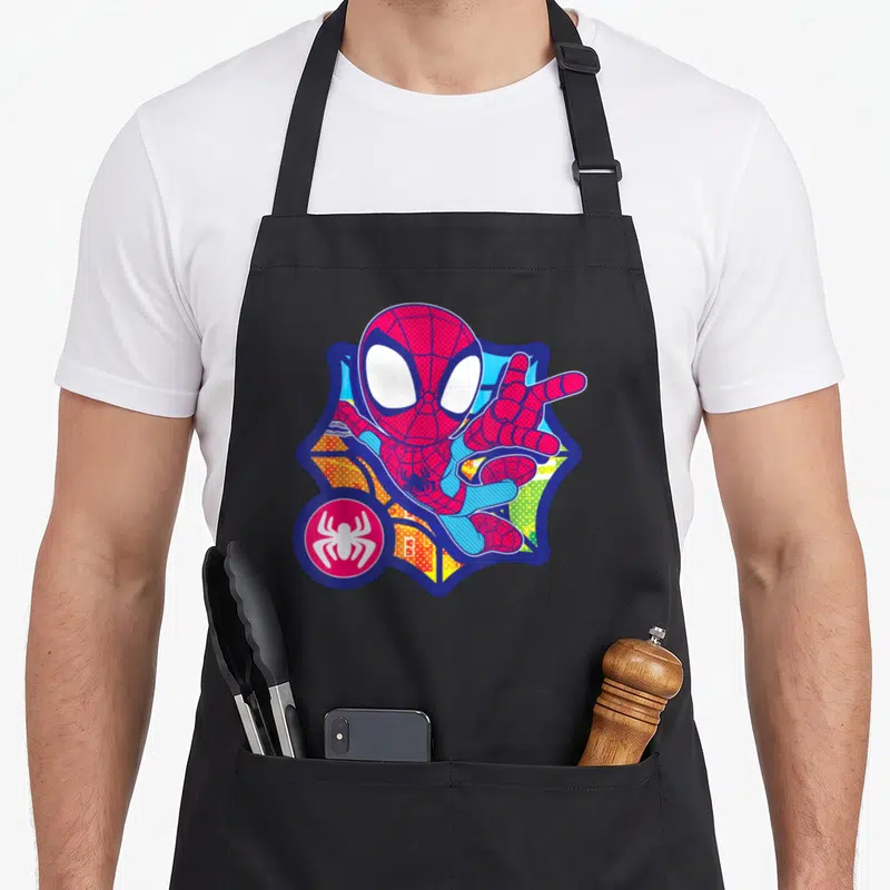 Tablier de cuisine noir avec illustration colorée de Spider-Man en pose dynamique et effet pointillé comics.