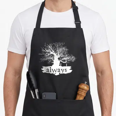 Tablier de cuisine noir avec un arbre blanc aux branches détaillées et le mot always en bannière.