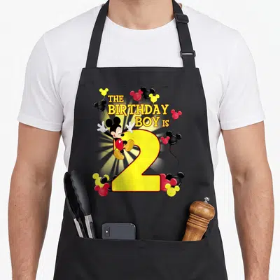 Tablier de cuisine noir avec Mickey Mouse et le chiffre 2 entouré de ballons colorés.
