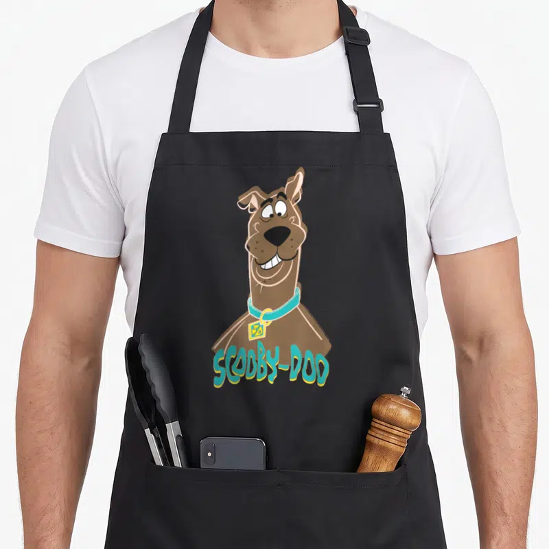 Tablier de cuisine noir avec illustration colorée de Scooby-Doo et son nom imprimé en bas.