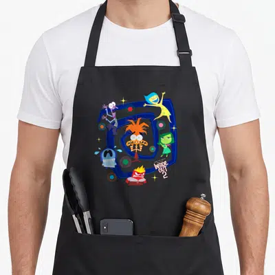 Tablier de cuisine noir avec illustration colorée de la Spirale Emotionnelle et personnages d'Inside Out 2.