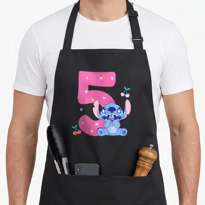 Tablier de cuisine noir avec Stitch en enfant devant un grand chiffre 5 rose entouré d'étoiles et de cerises.