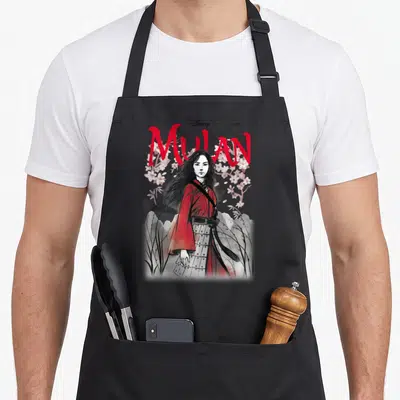 Tablier de cuisine noir avec illustration de Mulan en robe rouge entourée de fleurs roses et du titre en lettres rouges.
