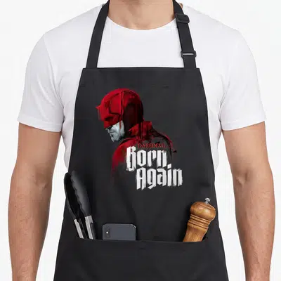 Tablier de cuisine noir avec l'illustration stylisée de Daredevil et le texte Born Again en blanc.