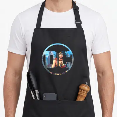 Tablier de cuisine noir avec logo Wonder Woman circulaire illustration héroïne ville ciel