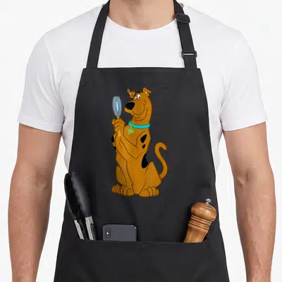 Tablier de cuisine noir avec Scooby-Doo tenant une loupe bleue et un collier turquoise.