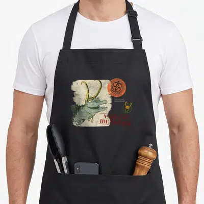 Tablier de cuisine noir avec illustration Loki alligator portant un casque doré et le texte Variant Identified en rouge.