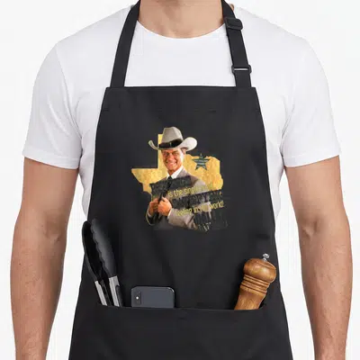 Tablier de cuisine noir avec illustration d'un homme en chapeau cowboy et texte Revenge is the single most satisfying Dallas TV Series.