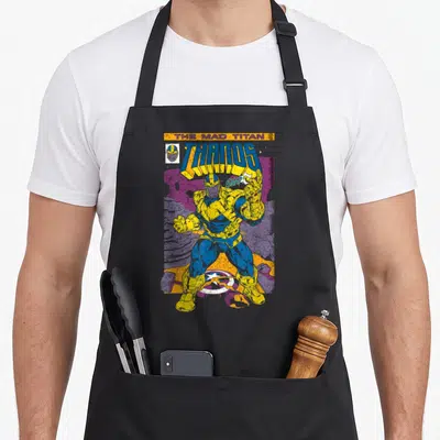 Tablier de cuisine noir avec illustration colorée de Thanos en style comic book rétro sur fond violet et jaune.
