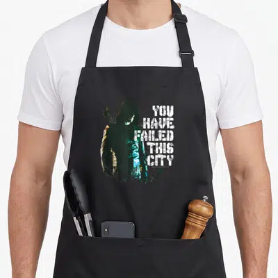 Tablier de cuisine noir avec le Green Arrow et l'inscription You Have Failed This City en blanc.